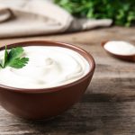 Bowl,Of,Fresh,Sour,Cream,With,Parsley,On,Wooden,Table
