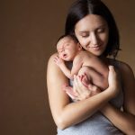 Young,Mother,Holding,Her,Newborn,Sleeping,Baby