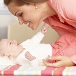 Happy,Mother,Playing,With,Lying,Baby,Girl,,Smiling,,Talking.
