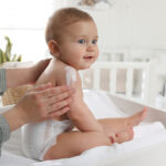 Mother,Applying,Body,Cream,On,Her,Little,Baby,At,Home,