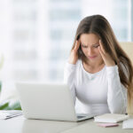 Young,Frustrated,Woman,Working,At,Office,Desk,In,Front,Of