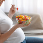 Unrecognizable,Pregnant,Lady,Eating,Fresh,Vegetarian,Salad,From,Bowl,,Enjoying