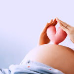 Pregnant,Woman,Holds,In,Palms,Symbol,In,Heart,Shape.,Loving