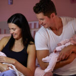 Parents,At,Home,Cuddling,Twin,Baby,Daughters,In,Nursery