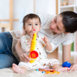 Mom,And,Baby,Playing,Musical,Toys,At,Home