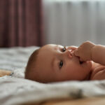 Closeup,Portrait,Infant,Baby,Holding,Fingers,In,Its,Mouth,Trying