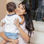 Beautiful,Young,Happy,Indian,Mother,Wearing,White,Dress,Holding,Cute