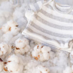 Delicate,White,Cotton,Flowers,Baby’s,Textile,Clothes,On,A,Wooden