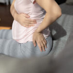Late,Pregnant,Woman,Suffering,From,Backache,,Sitting,On,Couch,,Holding