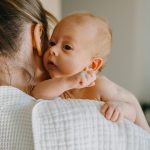 Mother,Holding,Newborn,Baby,On,Shoulder,,With,A,Burping,Cloth.
