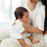 Mother,Holding,Newborn,Baby,Burping,In,A,Bedroom,After,Feeding