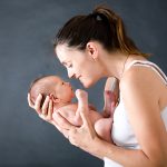 Young,Mother,,Kissing,And,Hugging,Her,Newborn,Baby,Boy,,Tender,