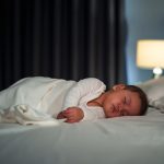Infant,Baby,Sleeping,On,A,Bed,At,Night