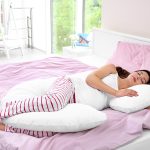 Young,Pregnant,Woman,Sleeping,On,Maternity,Pillow,At,Home